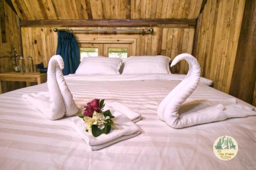 łóżko z ręcznikami i kwiatami na górze w obiekcie TVpalm Ecolodge w mieście Hà Giang