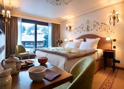 a hotel room with a bed and a table and chairs at Hôtel de la Loze in Courchevel