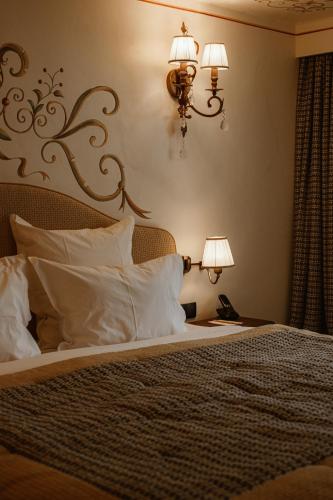 a bedroom with a bed with two lamps and two pillows at Hôtel de la Loze in Courchevel