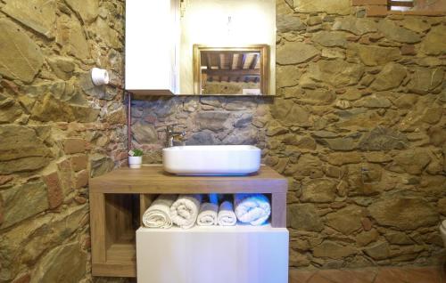 La salle de bains est pourvue d'un lavabo et d'un mur en pierre. dans l'établissement Casale Stella Nova, à Grosseto