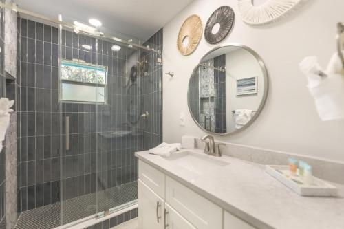 a bathroom with a shower and a sink and a mirror at Turtle Tracks East in Sanibel