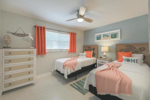 a bedroom with two beds and a ceiling fan at Turtle Tracks East in Sanibel