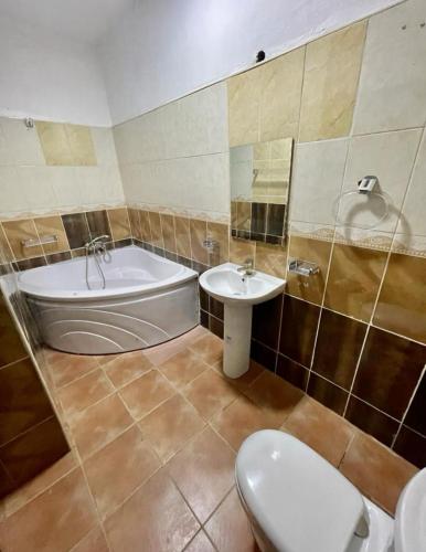 a bathroom with a tub and a toilet and a sink at AL_MUBARAK ,APARTMENT in Ikeja