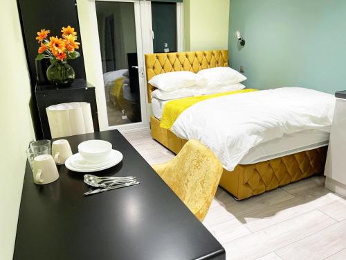 Un dormitorio con una cama y una mesa con platos. en Letzi Private En-Suite In Harrow, en Pinner