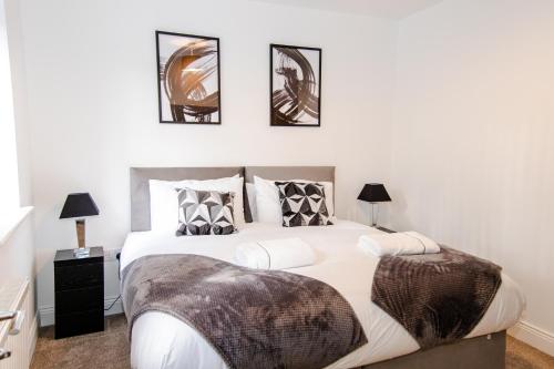 1 dormitorio con 1 cama blanca grande y 4 cuadros en la pared en Monthly Discounts: Luxury House Near Durham City en Durham