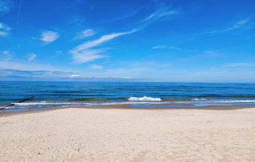a beach with the ocean on a sunny day at 2 Bedroom Amazing Home In Mielno in Mielno