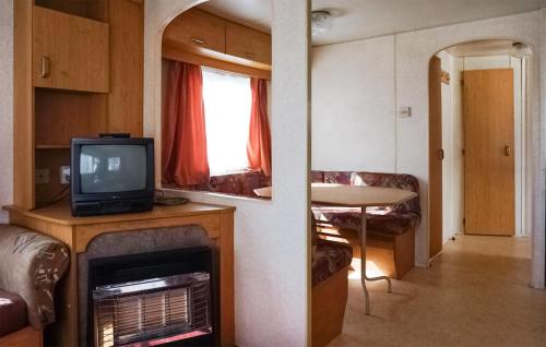 a room with a tv and a living room with a fireplace at 2 Bedroom Amazing Home In Mielno in Mielno