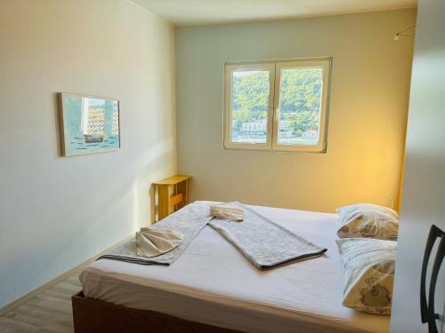 uma cama num quarto com duas janelas em Dubrovnik Apartments em Dubrovnik