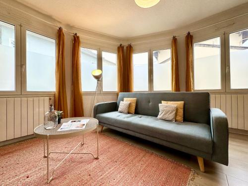 a living room with a couch and some windows at LE COSY - Plain-Pied in Mont-de-Marsan