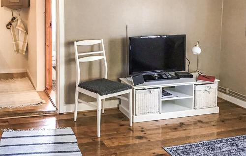 a room with a desk with a television and a chair at Awesome Home In Visby With Kitchenette in Vall