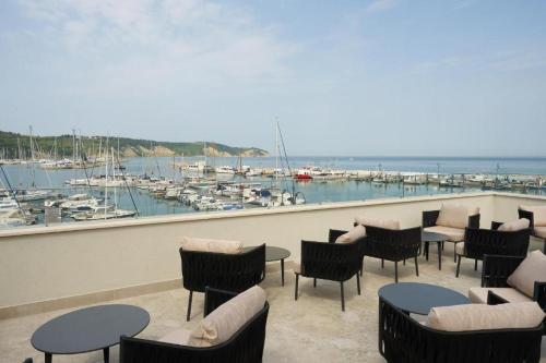 a balcony with tables and chairs and a marina at Villa Noa jacuzzi & sauna in Izola