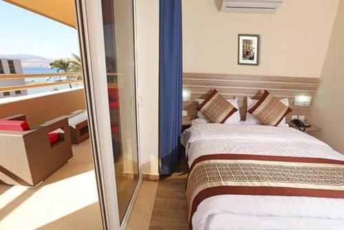 a hotel room with two beds and a balcony at La Riva Hotel in Aqaba