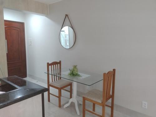 a dining room with a table and chairs and a mirror at Apto 115 N B a 6 km do aeroporto in Núcleo Bandeirante