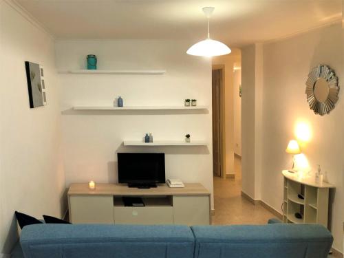 a living room with a blue couch and a tv at PDL Central Apartments - One in Ponta Delgada