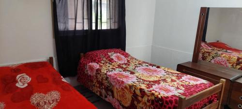 a bedroom with a bed and a mirror at Casita vacacionera in Bialet Massé