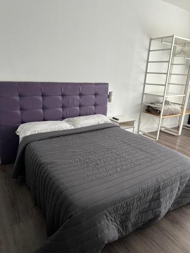 a large bed with a purple headboard in a bedroom at AP DEUSTO in Bilbao