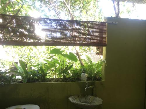 a bathroom with a window with a window shade with plants at Confetti House in Quy Nhon