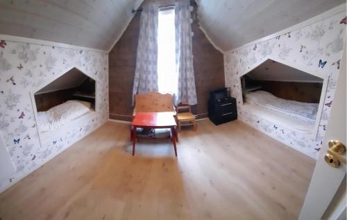 an attic room with two beds and a table at 4 Bedroom Awesome Home In Mykland in Mykland