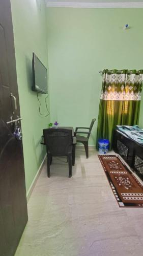 a living room with a tv and a couch and a chair at Prakash Homestay in Ayodhya