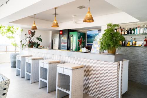 - un bar avec des tabourets en osier blanc dans un restaurant dans l'établissement Hotel Cabo Branco Atlântico, à João Pessoa