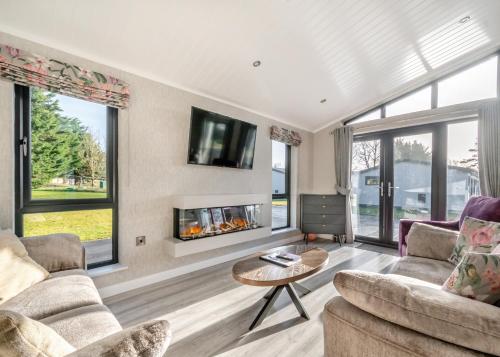 a living room with two couches and a fireplace at Faringdon Grange in Faringdon