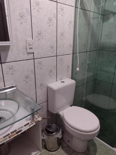 uma casa de banho com um WC, um chuveiro e um lavatório. em Casa Capao da Canoa em Capão da Canoa