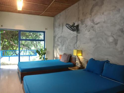 1 dormitorio con 2 camas y pared de piedra en Confetti House, en Quy Nhon