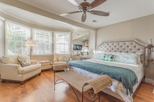 een slaapkamer met een bed, een bank en een ventilator bij Creekside Paradise in Tybee Island