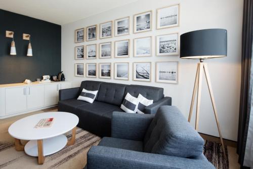 a living room with a blue couch and a table at Mercure Gdynia Centrum in Gdynia