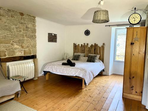 a bedroom with a bed and a stone wall at Les Gîtes du Fraysse, au paradis des oiseaux in Montignac