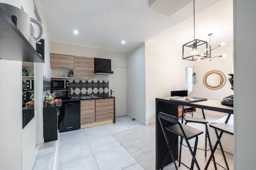 une cuisine avec un comptoir noir et un îlot de cuisine dans l'établissement Le GRAND JEAN - CENTRAL PRES GARE ET TRAM - supermarchés - WIFI - 3 Person, à Nice