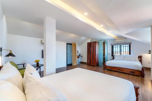 1 dormitorio con 1 cama grande y 1 sofá en La An Old Town Hotel, en Hoi An