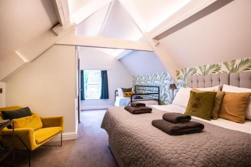 1 dormitorio con 1 cama grande y sillas amarillas en The Prince of Waterloo - Boutique Guest Rooms en Winford