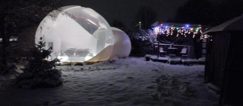 a snow covered yard with an igloo at night at La bulle 