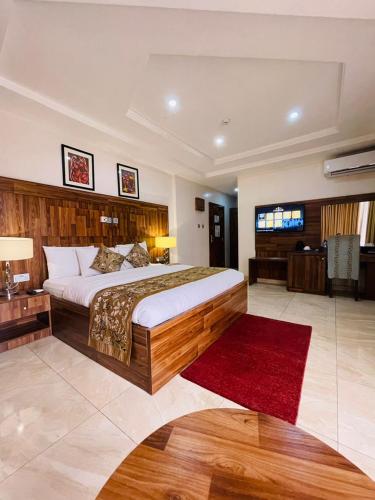 a bedroom with a large bed and a red rug at Qualibest Grand Hotels in Abuja
