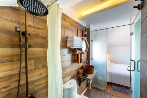 y baño con paneles de madera y ducha. en La An Old Town Hotel, en Hoi An