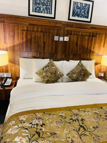 a bedroom with a large bed with two pillows at Qualibest Grand Hotels in Abuja