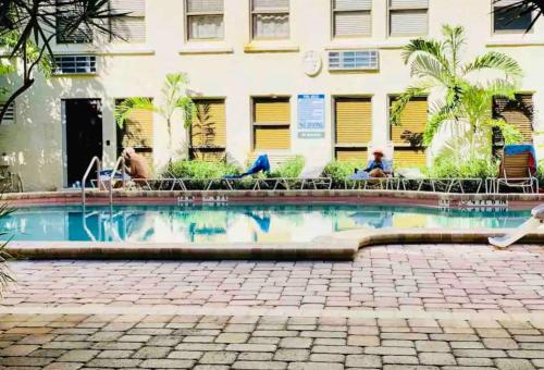 a swimming pool in front of a building at Romantic Studio in the Heart of Palm Beach in Palm Beach