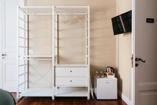 a white closet with a dresser and a tv at b&b le 4 leggende in Catania