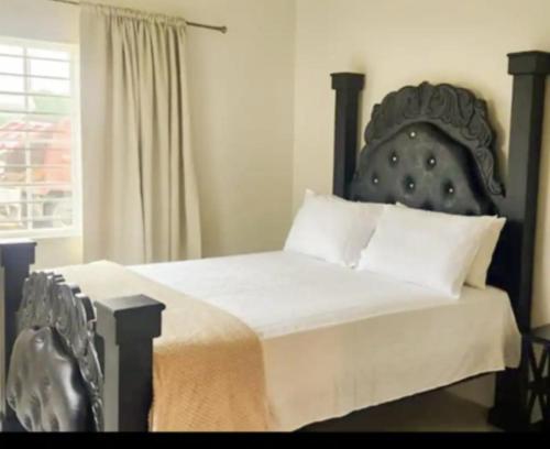 a bedroom with a bed with a large headboard at Remarkable 2-Bed House in Discovery Bay in Discovery Bay