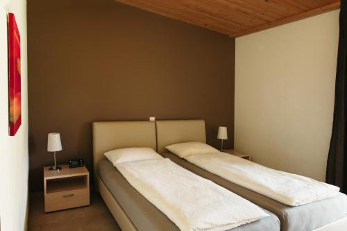 two beds in a room with two nightstands at Centro Magliaso in Magliaso