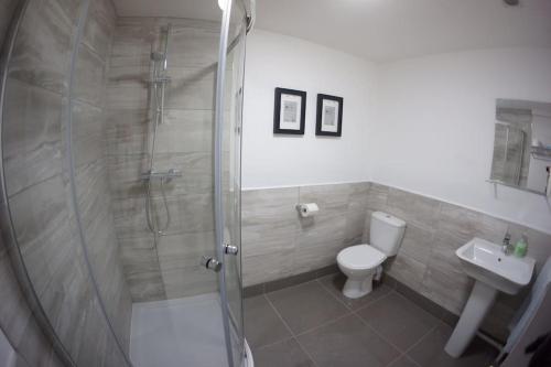 a bathroom with a shower and a toilet and a sink at City Centre Georgian Qtr Apartment Canning St 2bed 2bath in Liverpool