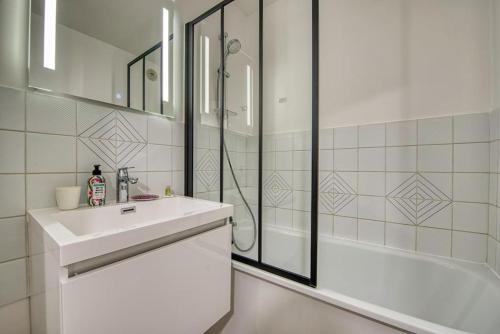 ein weißes Badezimmer mit Waschbecken und Dusche in der Unterkunft La Perle de Houlgate Élégance & Vue 4 pers in Houlgate