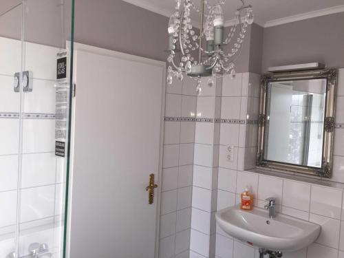 baño con lavabo y lámpara de araña en Gästehaus Stadt Land Fluss, 