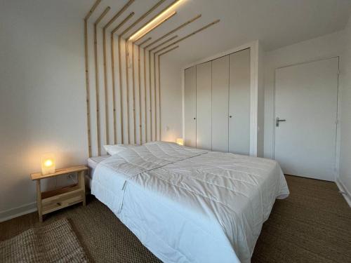 une chambre avec un lit blanc et deux bougies sur une table dans l'établissement LePrinceDeGalles, à Le Touquet-Paris-Plage