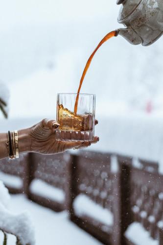 a person is holding a glass of drink at Hôtel de la Loze in Courchevel