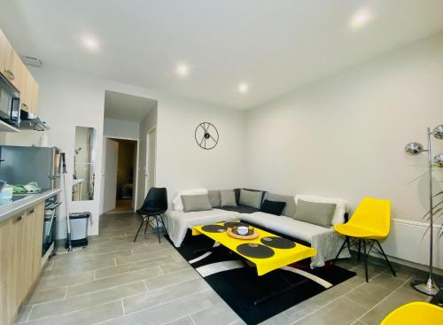 a living room with a couch and a yellow table at « La Bicyclette » 35m2 tout équipé centre ville in Mayenne