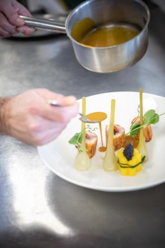 a plate of food on a table with a bowl of soup at Hôtel La Plage 5 étoiles La Grande Motte in La Grande-Motte