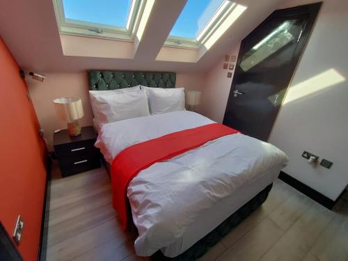 a bedroom with a large bed with a red blanket at Letzi Private En-Suite In Harrow in Pinner