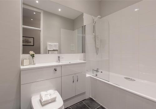 une salle de bain blanche avec un lavabo et des toilettes dans l'établissement West Bow Apartment, à Édimbourg